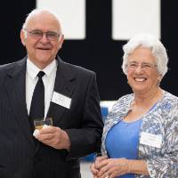 Guests holding drinks and smiling at Enrichment.